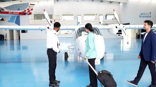 Pilot begrüßt Passagiere beim Einsteigen in ein Privatflugzeug im Hangar