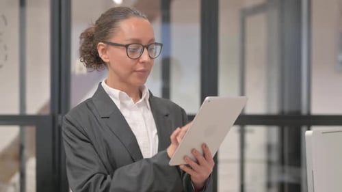 Portrait of Hispanic Business Woman Celebrating Success on Tablet