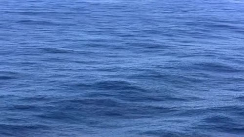 Aerial view of gently rolling ocean waves on a calm day.