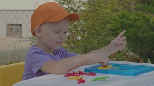 Three Year Old Boy Putting Togeather A Puzzle In Home Garden 1