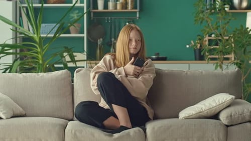 Teen Girl Relaxing At Home With Smartphone