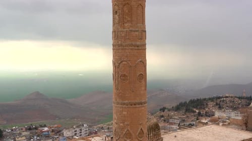 Mardin Ulu Camii minaret on a hazy day over looking Mezopotamia. Historical ornamentation all over t