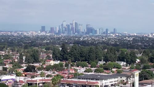 Drone View of Hazy Skyline of Downtown Business District Los Angeles from Residential Suburbs, Paral