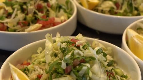 Salade de légumes frais servie dans des bols avec des tranches de citron sur le côté, gros plan