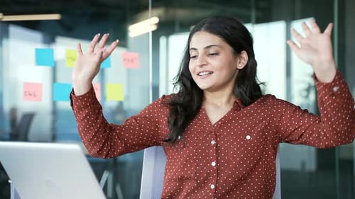 Happy young businesswoman finished work on laptop sitting at workplace in office. Smiling satisfied