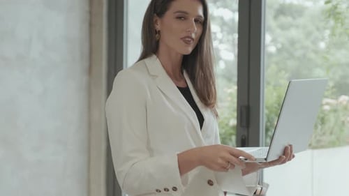 Young Woman Uses Laptop in Modern Office