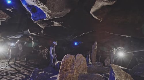 People Examining Stones in Cave