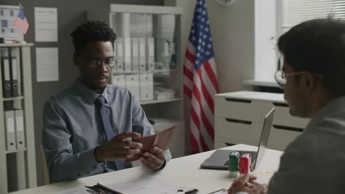 Visa Officer Reviewing Passport during Immigration Interview at US Embassy