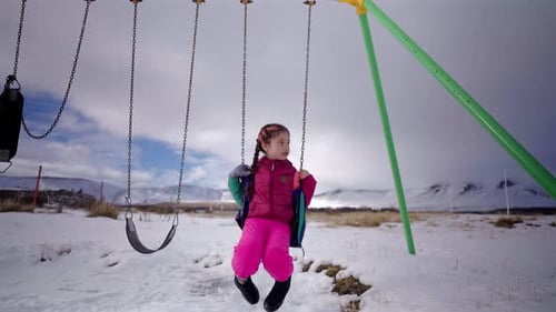 Child Enjoying a Swing on a Winter Day