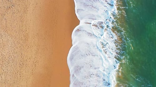 Aerial Drone Captures the Motion of Sea Waves on Sandy Beach