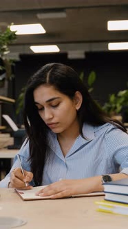 Young Indian Student Woman Writing and Studying with Laptop in Library