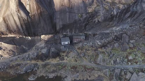 Two old historical houses under cliff in Norway. Drone footage