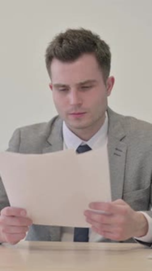 Young Businessman Reading Documents in Office, Paperwork, vertical video