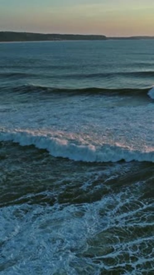 Aerial view on big ocean waves and sunset sky