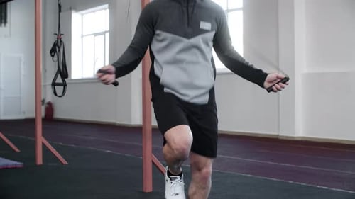 Midsection of Male Athlete Exercising with Jump Rope at Gym