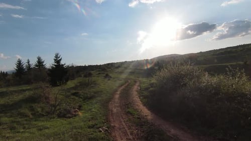 Vuelo rápido y maniobrable sobre la antigua carretera rural en montañas con pinos, bosques, árboles y