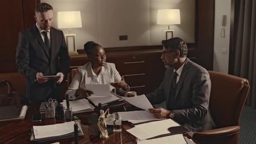 Diverse Lawyers Consulting Law Firm Manager on Previous Legal Cases