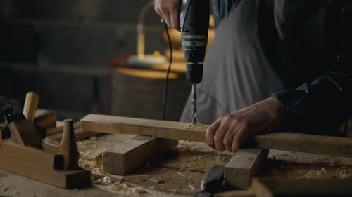 Craftsman Drilling Wood with Power Drill in Workshop