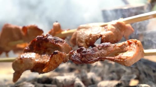 Brutzelnde Fleischspieße beim Grillen über dem Rauch Köstliches BBQ-Streetfood