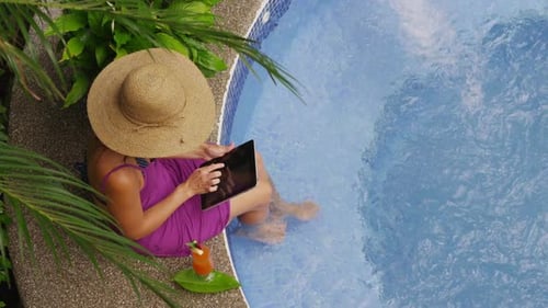 Woman Relaxing with Tablet by Pool