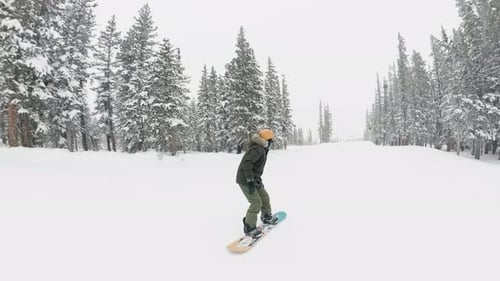 Der
Snowboarder macht einen hohen Sprung durch die Luft, während er auf die Schneerampe zurast. Weißer Schneefall lag