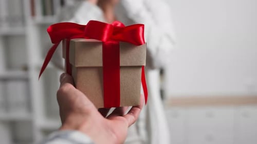 Giving Birthday Gift with a Red Bow