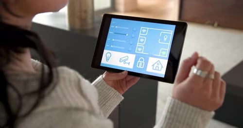 Woman Interacts With Smart Home Control Tablet