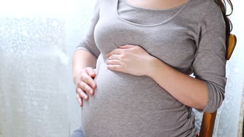 Pregnant Woman Holds and Rubs Belly