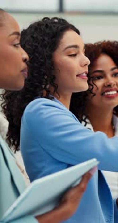 Three Smiling Women Brainstorm at Work