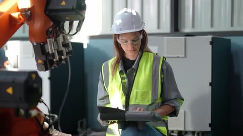 Female Engineer with Digital Tablet Examining Machine Equipment