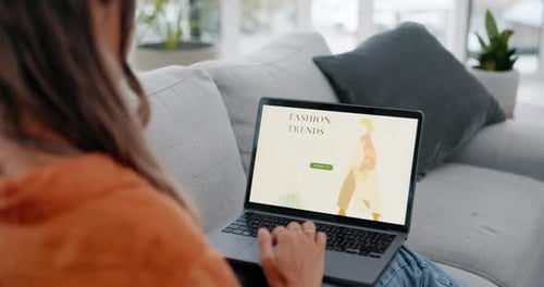 Woman, laptop and online shopping fashion website on living room sofa in ecommerce