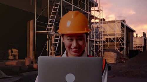 Nahaufnahme einer asiatischen Ingenieurin, die auf einer Baustelle an einem Laptop arbeitet