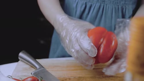Front View of the Young Chef Cut Thin Slices of a Piece of Red Pepper with a Knife on the Cutting