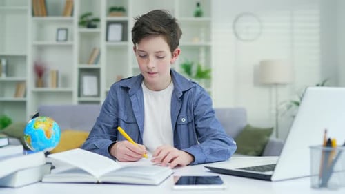 Teen Boy Studies Using Laptop at Home