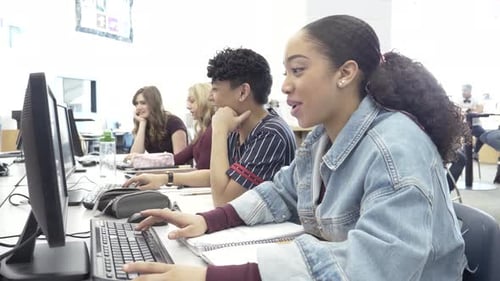 Highschool-Mädchen lernt online im Computerraum der Bibliothek mit Klassenkameraden