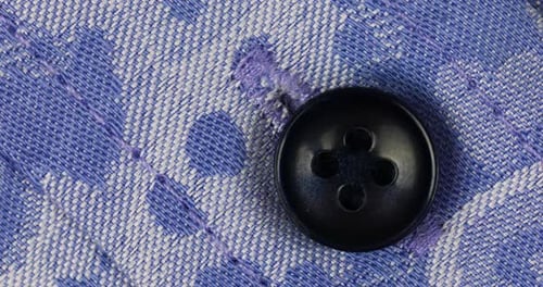 Close-Up of Black Button on Blue Shirt