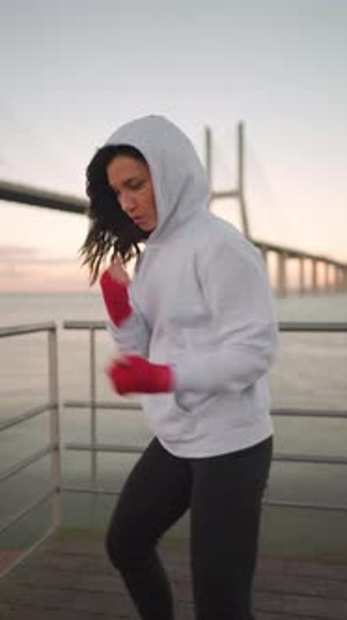 Woman Training Boxing at Sunrise by the Pier