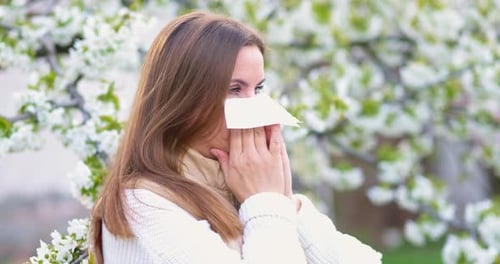 Woman With Allergies Using a Tissue Outdoors