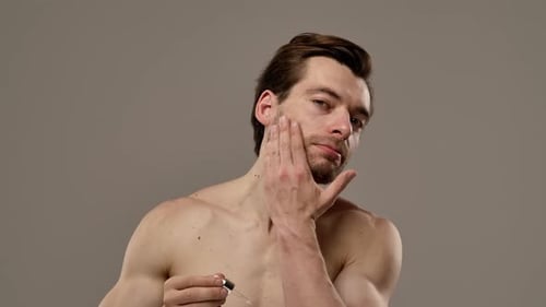 Man Applies Skin Serum to Face and Neck