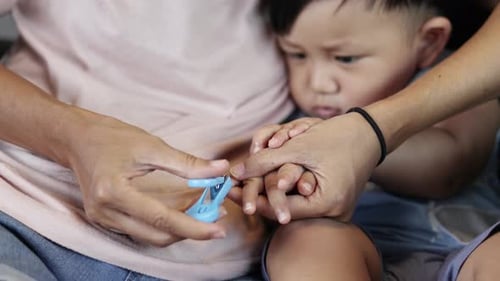 Adult Clipping the Nails of a Child
