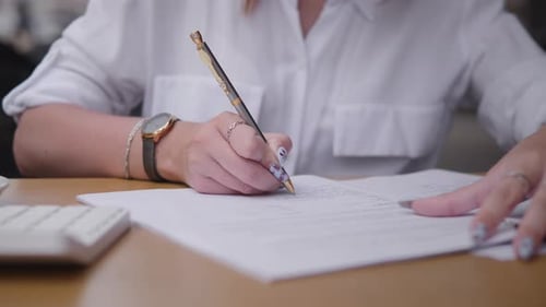 Woman Signing Document in Bright Office Environment