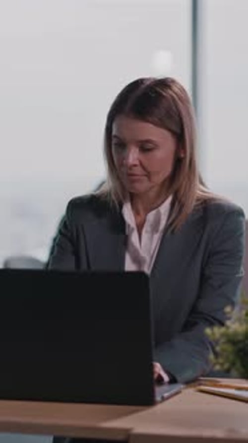 Focused Woman Working on Laptop in Modern Office
