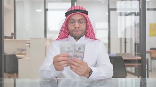 Man Counting Cash in Bright Office