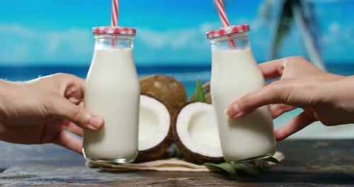 Delicious fresh nutritious coconut milkshake on the background of the sea, palm and sky, the conce