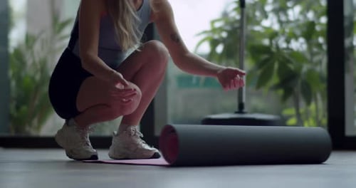 Woman Unrolls Yoga Mat for Exercise at Home