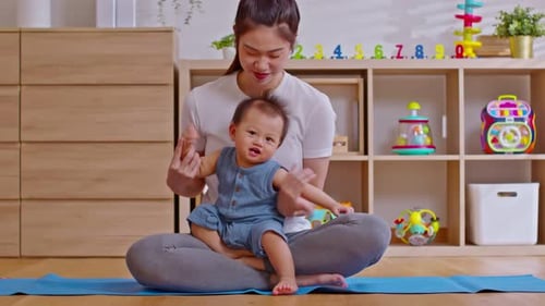 Woman Sitting with Baby on Yoga Mat