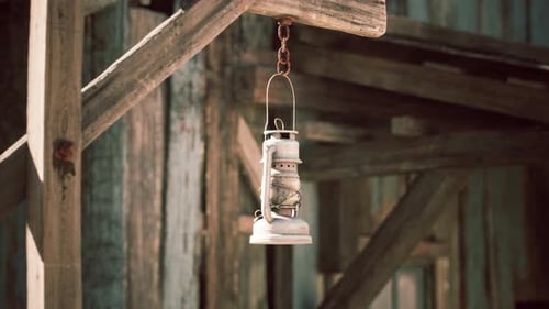 Rustic Lantern Hanging From a Wooden Beam in a Vintage Farm Setting