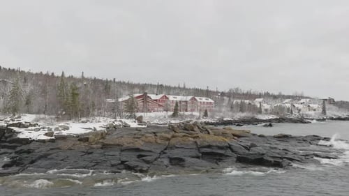 Winter Scenery On The North Shore Of Lake Superior. Snowy Cottages And Lodgings On Forested Landscap