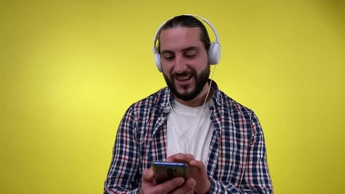Man with Headphones Enjoys Music on Phone