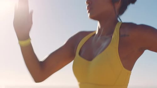 Active, sporty and athletic woman running fast while training and doing cardio workout on the beach